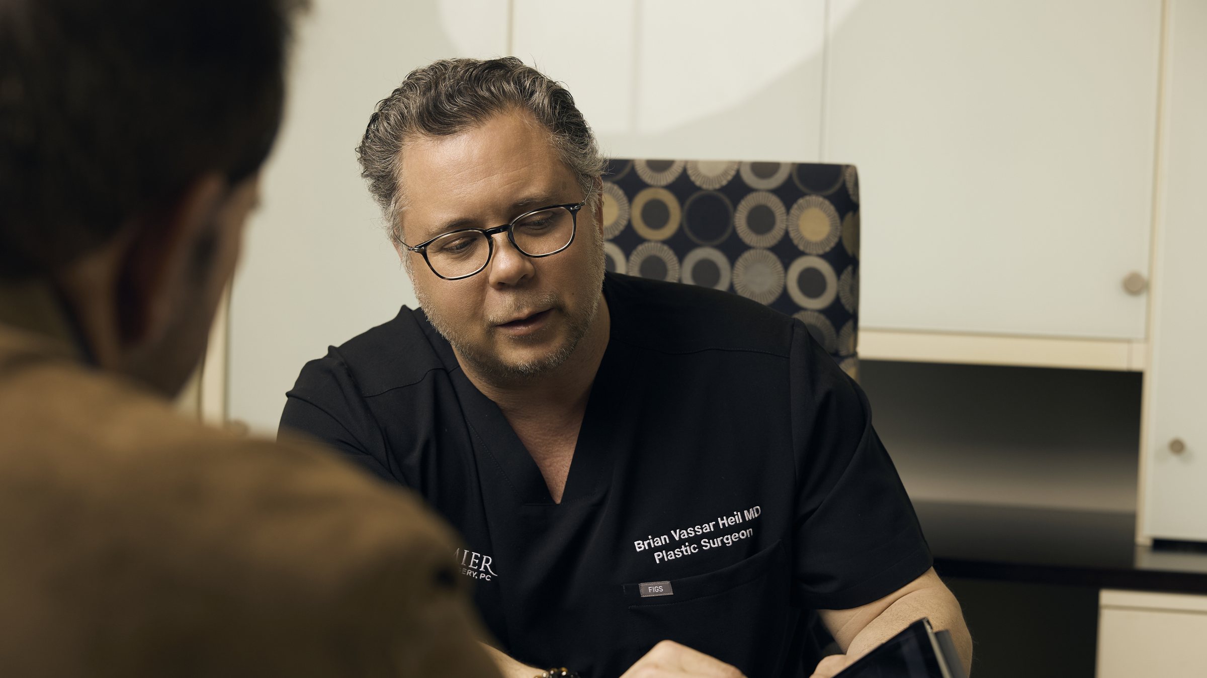 Dr. Heil in conversation with a patient across his desk