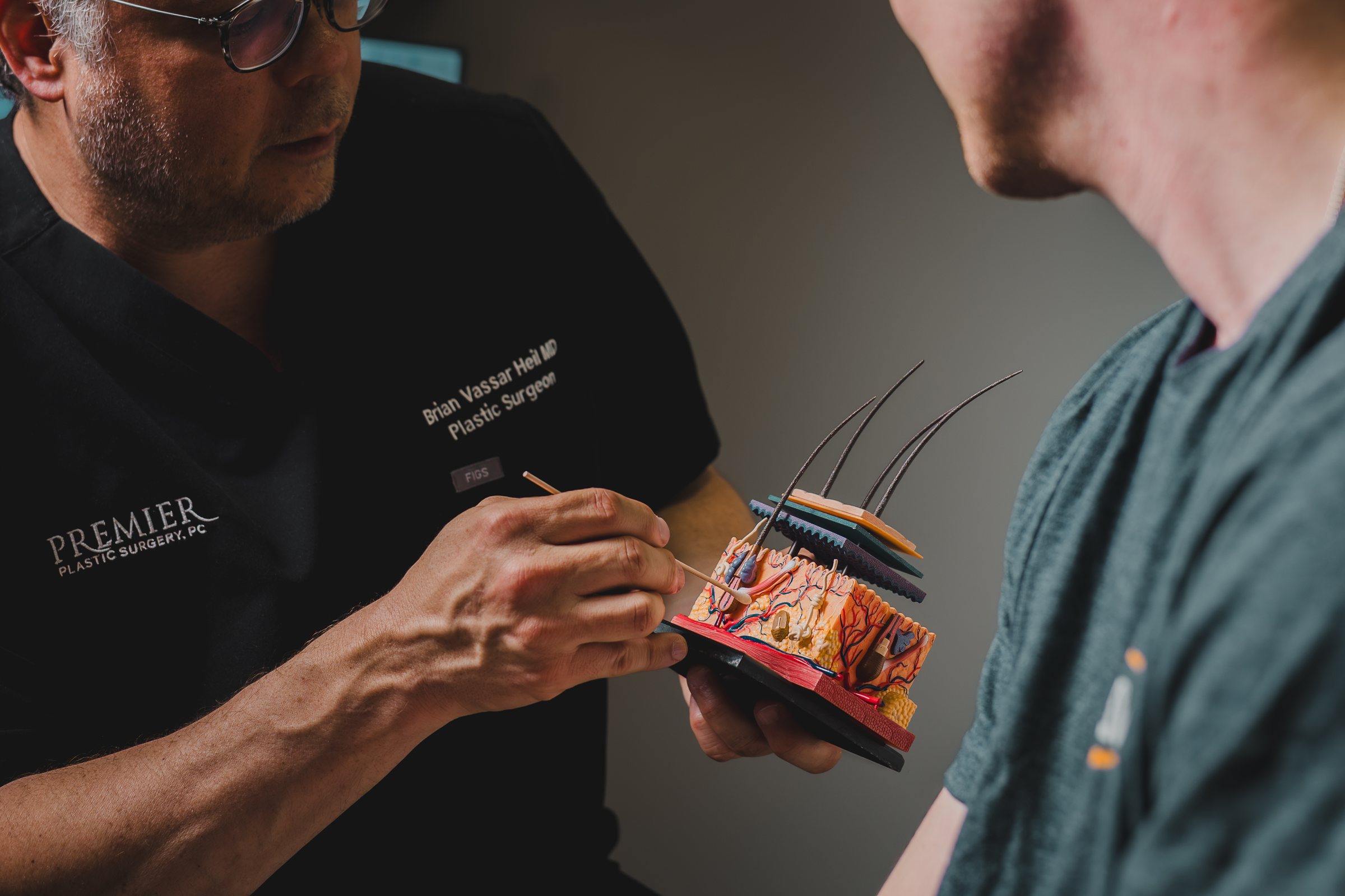 Dr. Heil examining a patient's hairline in the mirror