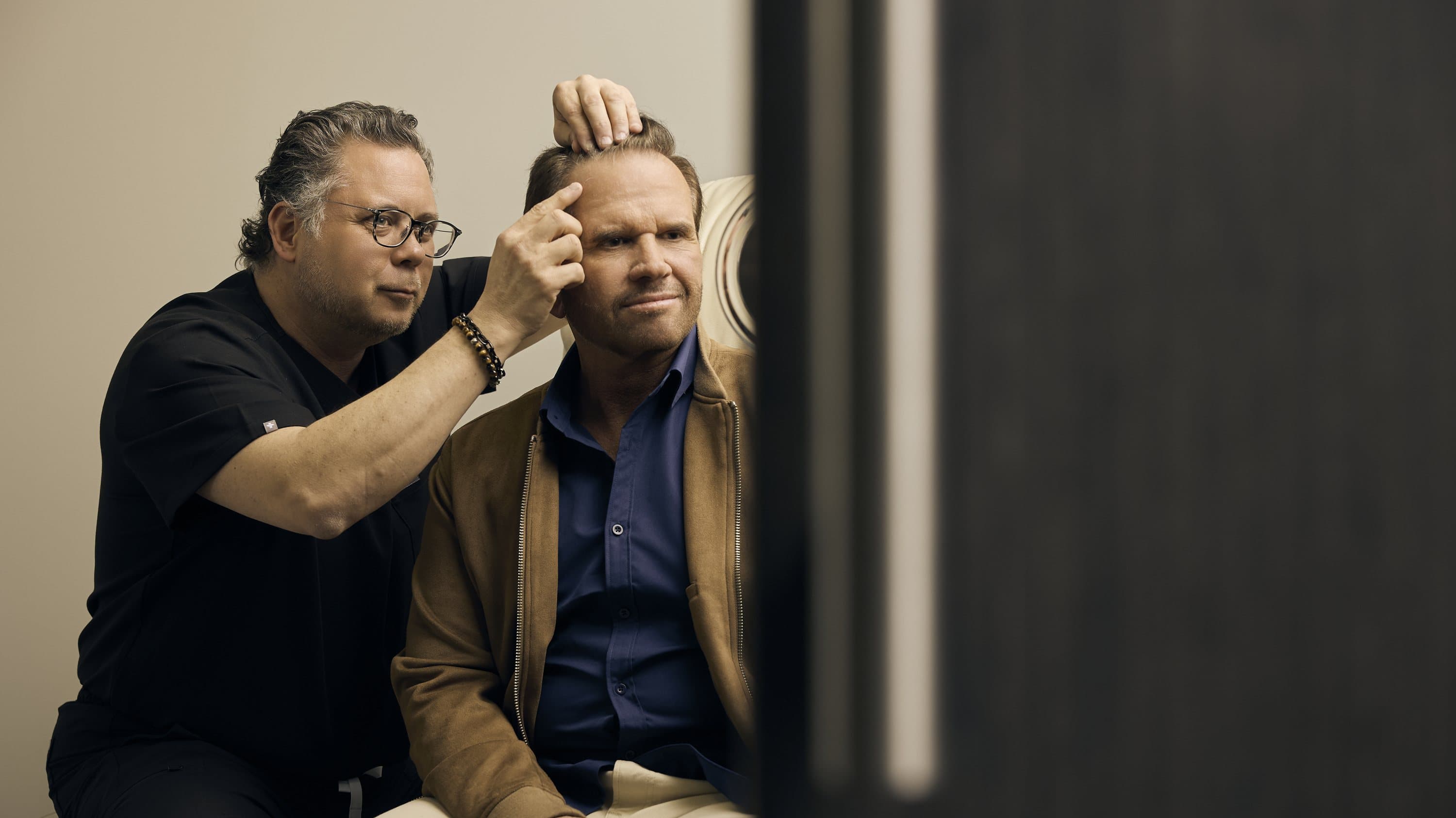 Dr. Heil examining a patient's hairline at a consultation