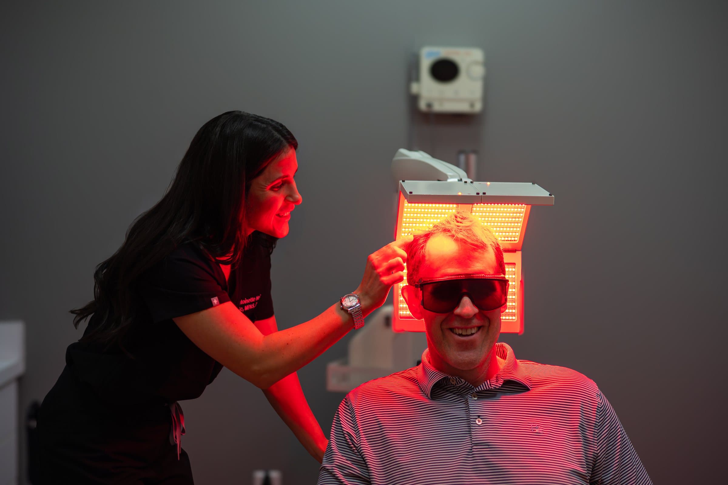 A patient under the NeoGraft red light therapy panel