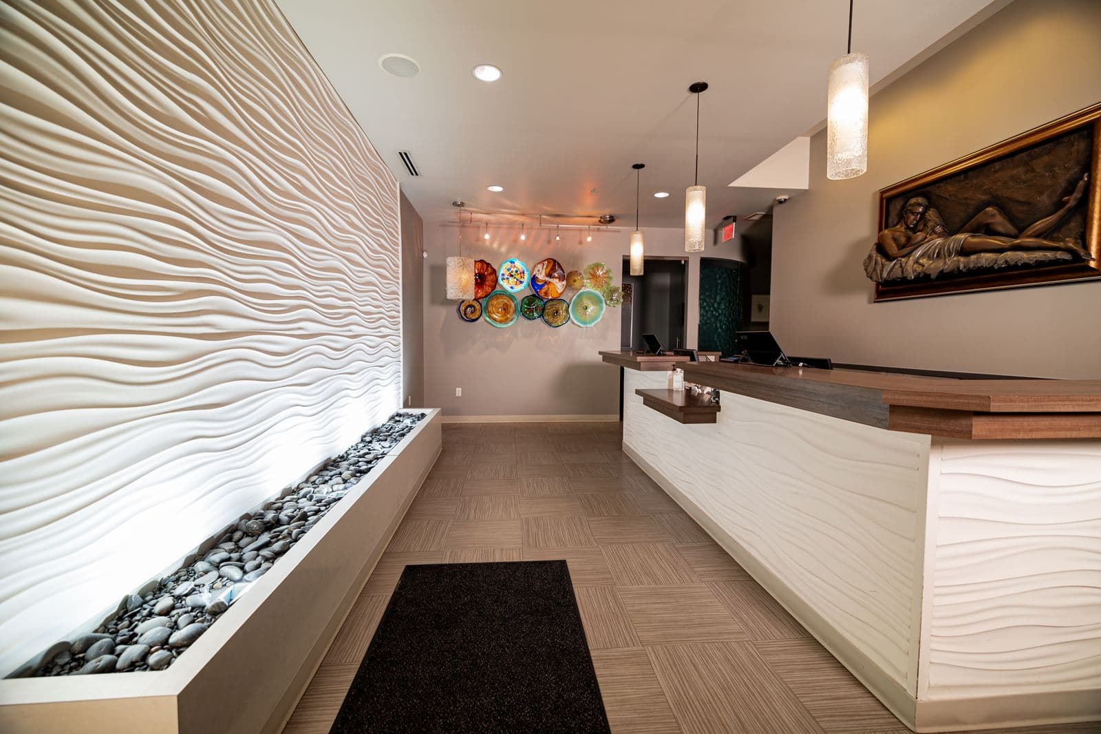 The Wexford reception, its wave-textured desk lit from beneath