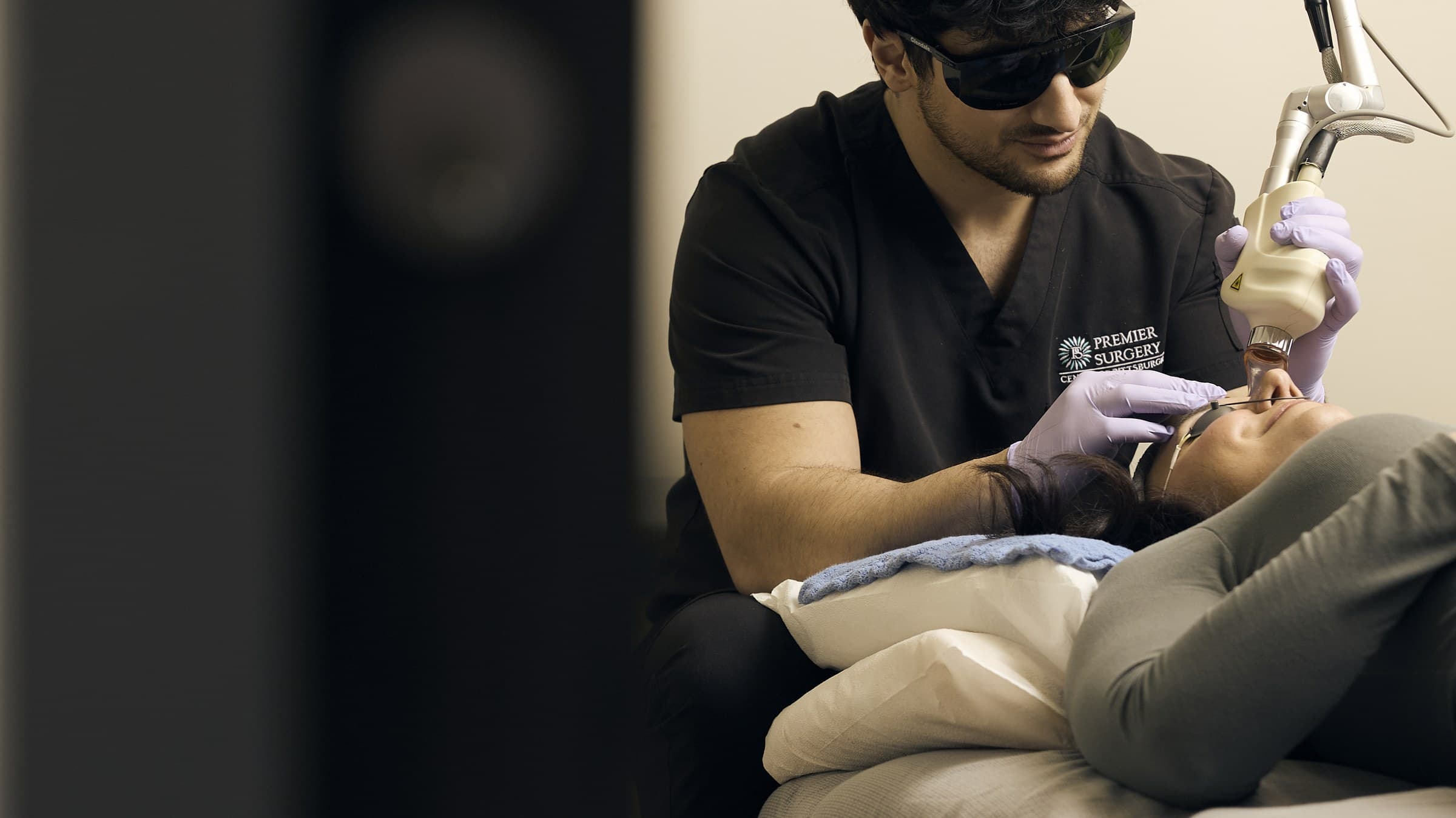 Tyler Jones, PA-C, guiding the CO2 laser handpiece over a patient's face