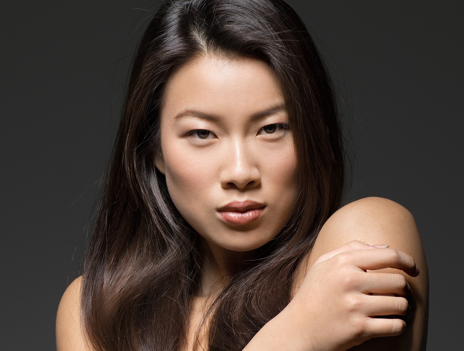 A woman turned slightly from the camera in low light