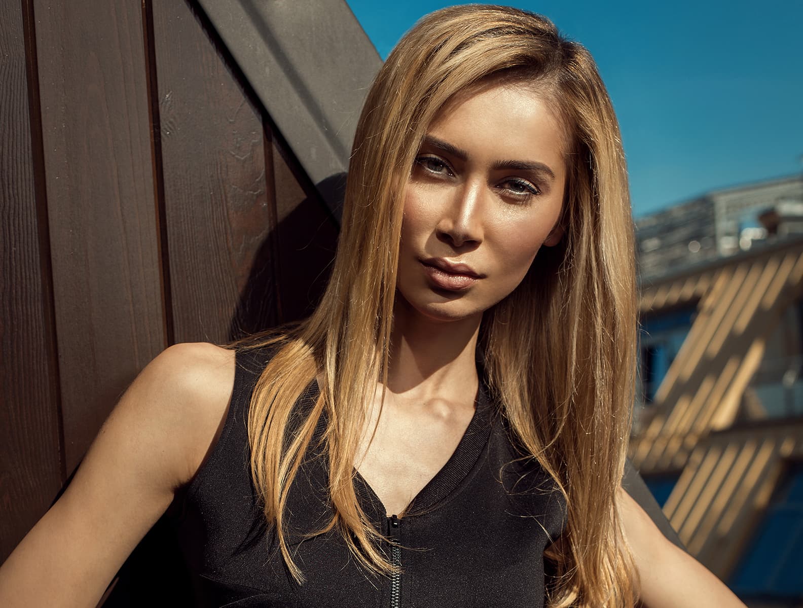 A woman with long blonde hair on a rooftop in evening light